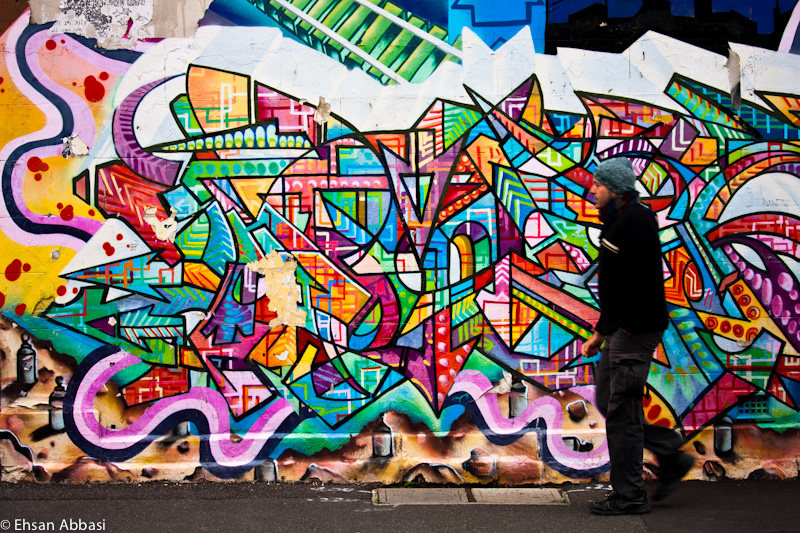 A man walks past graffiti